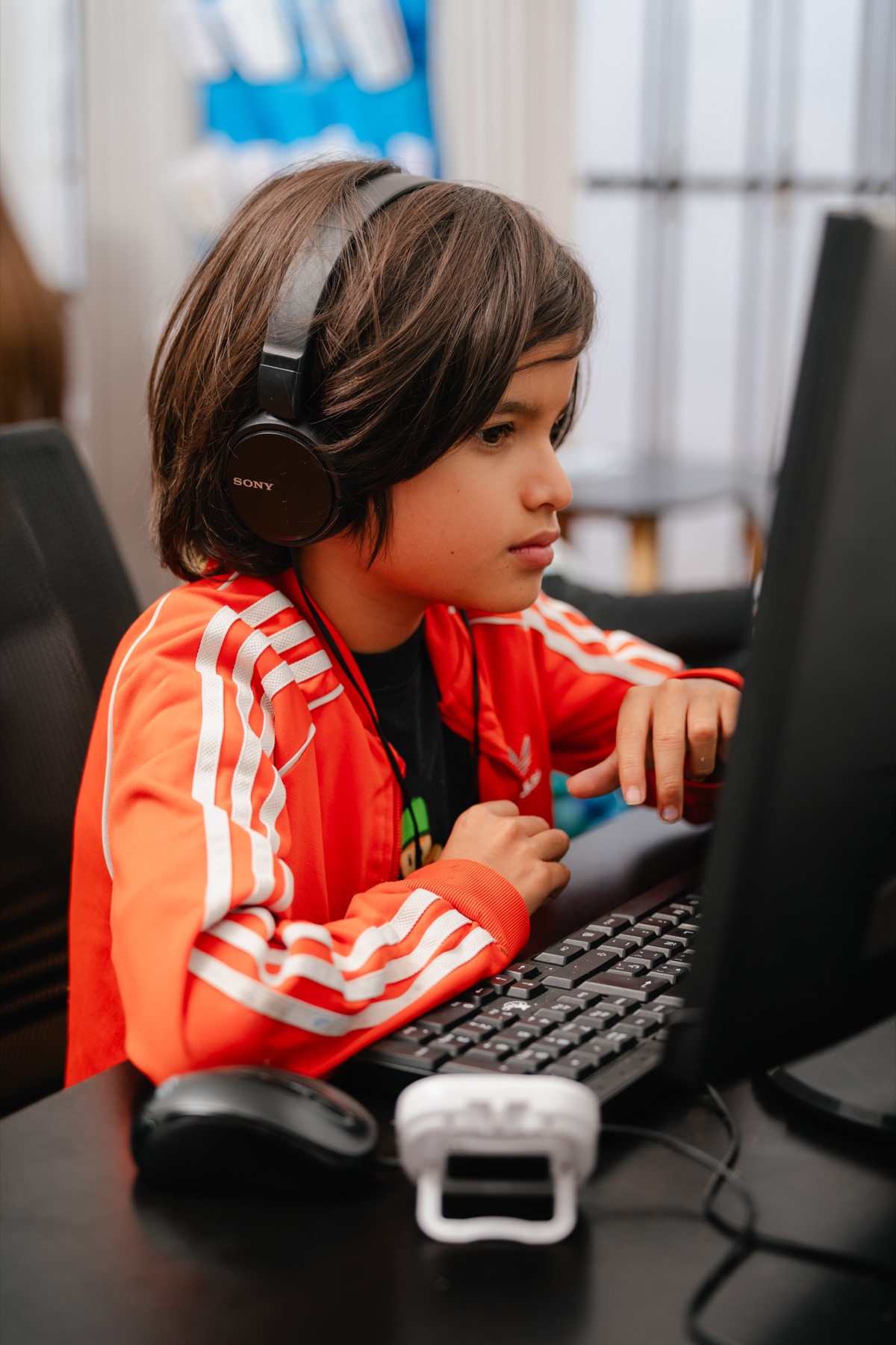 Un niño con audífonos concentrado durante un ejercicio en computadora