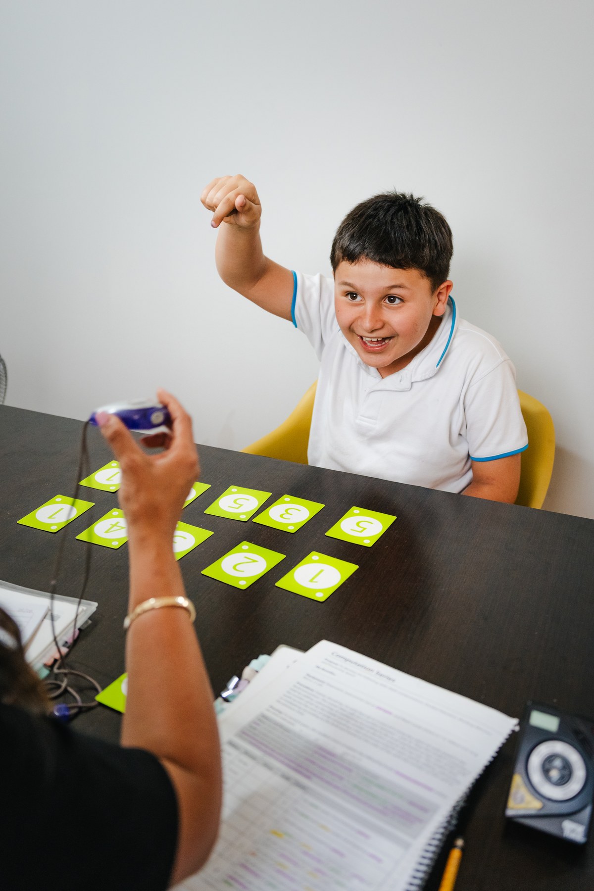Un estudiante en entrenamiento 1 a 1 con su psicóloga, usando tarjetas de números