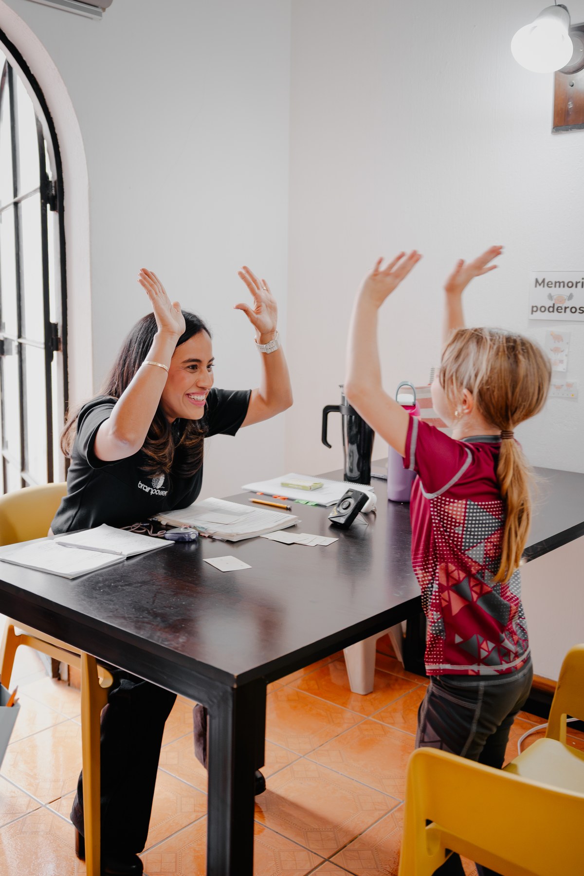 Una entrenadora y una estudiante celebrando con un high five